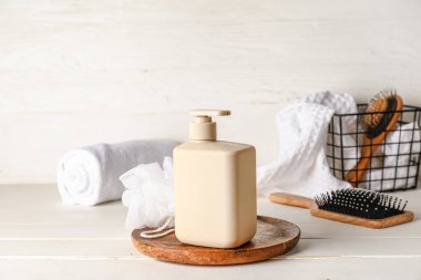 Arka planda bir şişe duş jeli ve banyo malzemeleri.