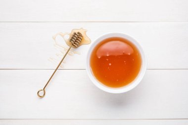 Tatlı ballı kase ve hafif ahşap arka planda kepçe