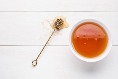 Tatlı ballı kase ve hafif ahşap arka planda kepçe