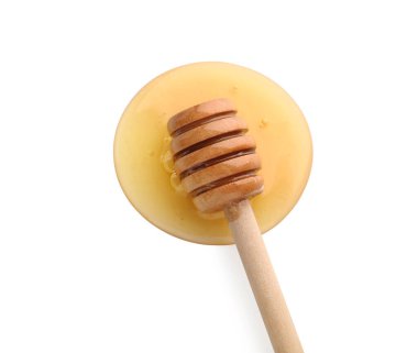 Tahta kaplama ve beyaz arka plana bal dökülmüş.