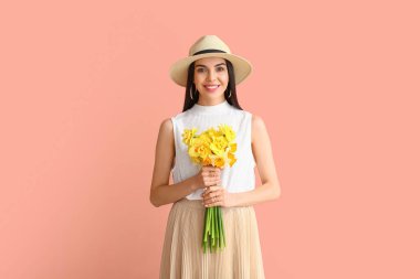 Arka planda narsis buketi olan güzel genç bir kadın.