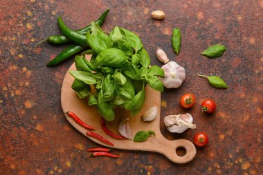 Taze fesleğen yaprağı, sarımsak, domates ve arkaplanda kırmızı biber kompozisyonu.