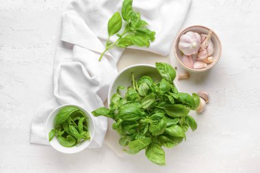 Taze fesleğen yaprakları ve arka planda sarımsak.