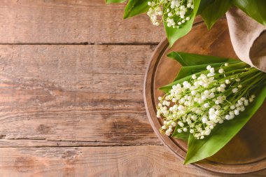 Ahşap arka planda güzel vadi zambakları olan tahta.