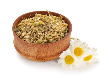 Beyaz arka planda kurumuş papatya çiçekleri olan bir kase.