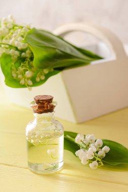 Kaliteli yağ şişesi ve ahşap arka planda zambak çiçeği.