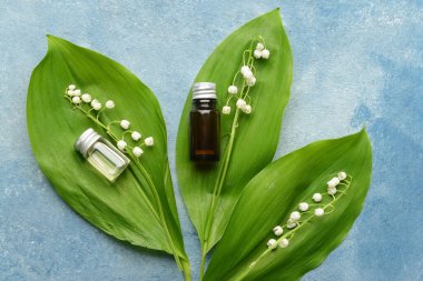 Gerekli yağlı şişeler ve arka planda zambak çiçekleri.