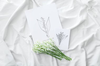 Vadideki güzel zambak çiçekleri ve açık kumaş arka planda tebrik kartı.