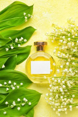 Bir şişe parfüm ve arka planda zambak.