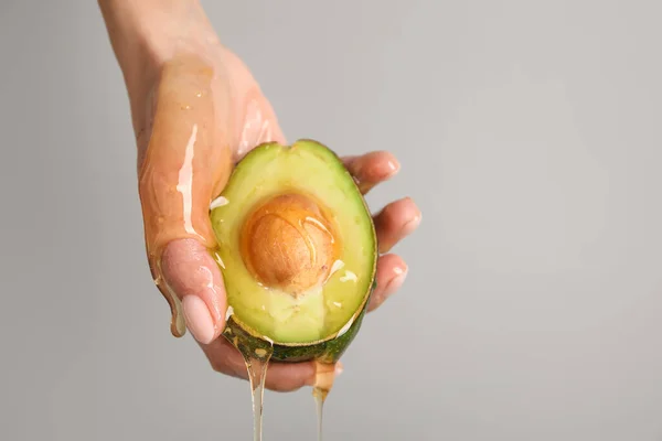 Female Hand Avocado Dripping Honey Grey Background Closeup — Stock Photo, Image
