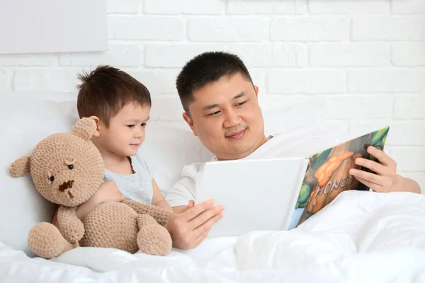 爸爸和他的小儿子在卧室看书 — 图库照片