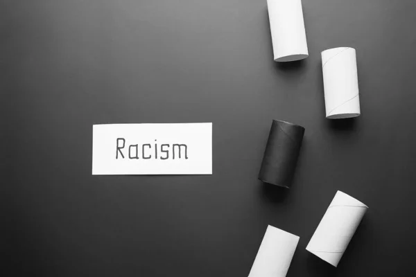 Χαρτί Λέξη Racism Και Σωλήνες Από Χαρτόνι Σκούρο Φόντο — Φωτογραφία Αρχείου