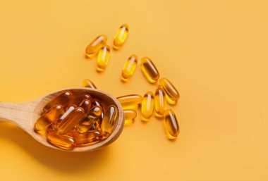 Renk arkaplanında balık yağı kapsüllü kaşık