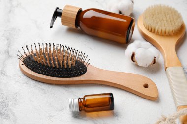 Açık arkaplanda saç fırçası ve kozmetik ürünleri olan kompozisyon