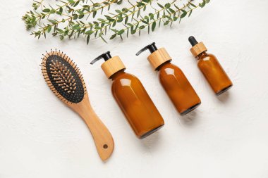 Hafif arkaplanda saç fırçası ve kozmetik ürünleri