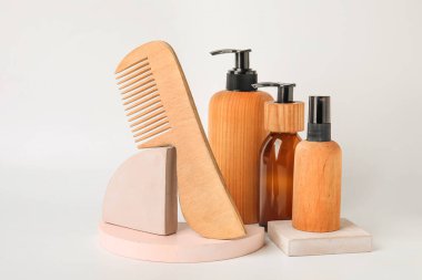 Hafif arkaplanda saç tarağı ve kozmetik ürünleri