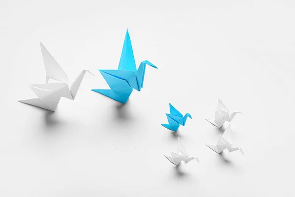 Origami birds on light background. Concept of uniqueness