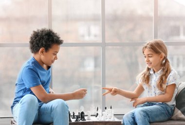 Evde satranç oynayan sevimli çocuklar.