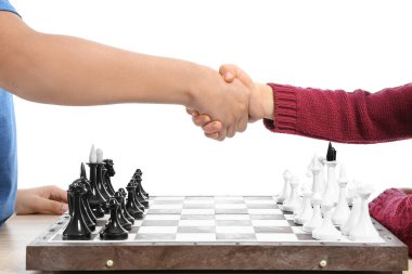 Beyaz arka planda satranç oynayan sevimli çocuklar.