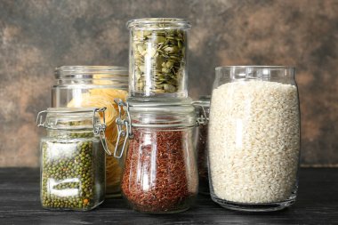 Grunge arka planında farklı ürünler olan cam kavanozlar