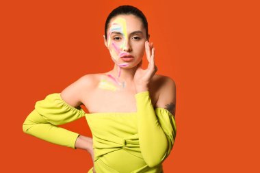 Güzel, genç bir kadın, vücudunda renk arkaplanı var.