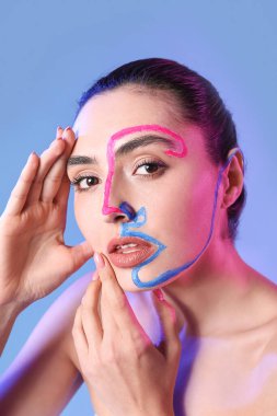 Renkli arka planda yüzü boyalı güzel bir genç kadın.