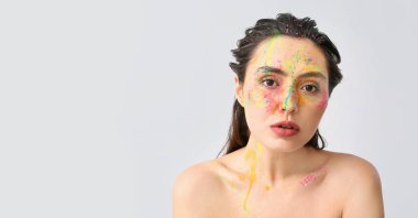 Yüzünde parlak bir arka plan olan güzel bir genç kadın.