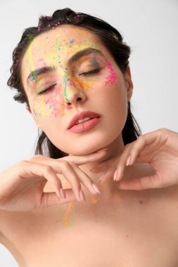 Yüzünde parlak bir arka plan olan güzel bir genç kadın.