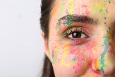 Yüzünde parlak bir arka plan olan güzel bir genç kadın, yakın plan.