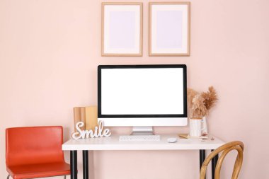 Renk duvarının yanındaki masada modern bilgisayarlı şık bir iş yeri