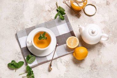 Bir fincan lezzetli yeşil çay, esrar ve arkaplanda bulunan malzemeler.