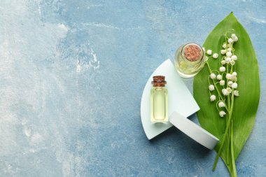 Gerekli yağlı şişeler ve arka planda zambak çiçekleri.