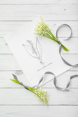 Vadideki güzel zambak çiçekleri ve hafif ahşap arka planda tebrik kartı.