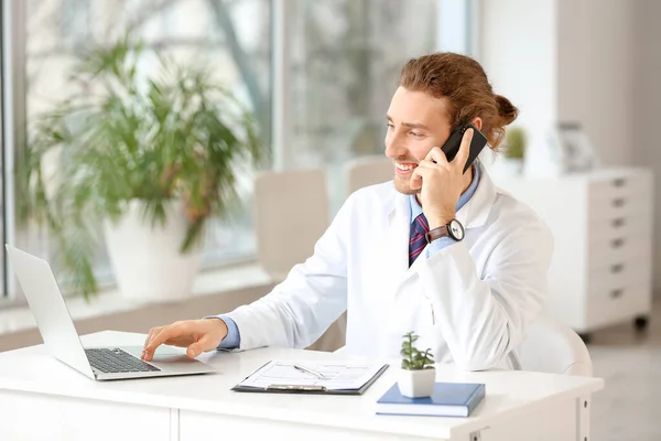 Giovane Medico Che Parla Con Telefono Cellulare Durante Utilizzo Laptop — Foto Stock