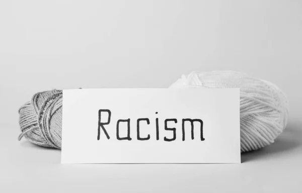 Χαρτί Λέξη Racism Και Πλέξιμο Νήματα Λευκό Φόντο — Φωτογραφία Αρχείου