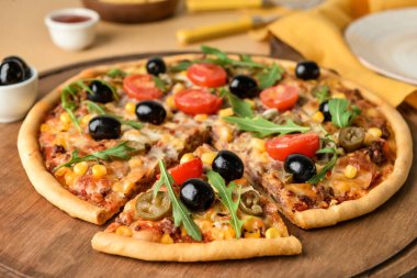 Renkli arka planda lezzetli pizzaya sahip tahta, yakın plan