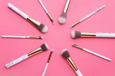 Renk arkaplanındaki makyaj fırçalarından yapılmış çerçeve