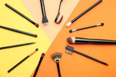 Renk arkaplanındaki makyaj fırçalarından yapılmış çerçeve