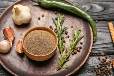 Koyu ahşap arka planda siyah biber tozuyla kompozisyon