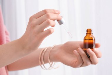 Kadın, hafif arka plana karşı eline gerekli yağı sürüyor, yakın plan.