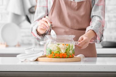 Kadın mutfakta lezzetli bir çorba pişiriyor.