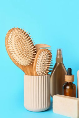 Renk arka planında saç fırçaları, tarak ve kozmetik ürünleri