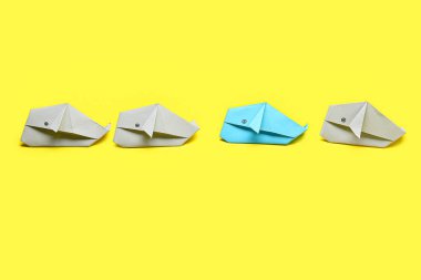 Renkli arka planda Origami balinaları. Eşsizlik kavramı