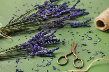 Güzel lavanta çiçekleri, makas ve ip renkli ahşap arka plan, yakın plan
