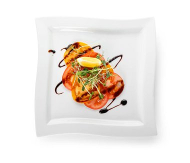 Beyaz arka planda lezzetli domates carpaccio tabağı.