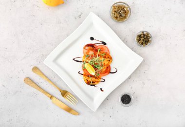 Açık arkaplanda lezzetli domates carpaccio tabağı.