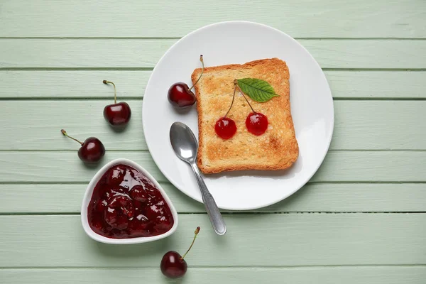 Schüssel Und Toast Mit Kirschmarmelade Auf Farbigem Holzhintergrund — Stockfoto