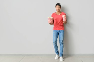 Işık duvarı yakınında patlamış mısırı olan Afro-Amerikalı bir genç.