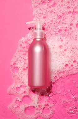 Suyun içinde renkli köpüklü bir şişe kozmetik ürünü.