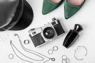 Arka planda fotoğraf makinesi olan kadın aksesuarları.